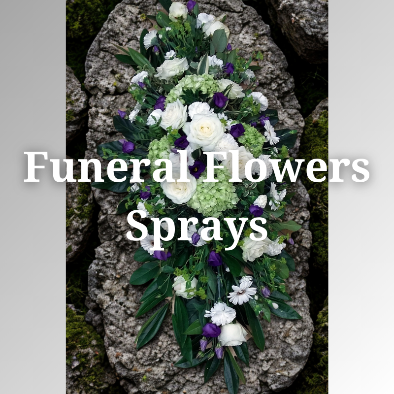 Funeral flower spray of white roses, purple blooms, and greenery